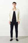 Men's Style - Model wearing Ra Denim Vin Tapered Black Jeans-1 with a black T-Shirt and a white jacket for a minimalist look