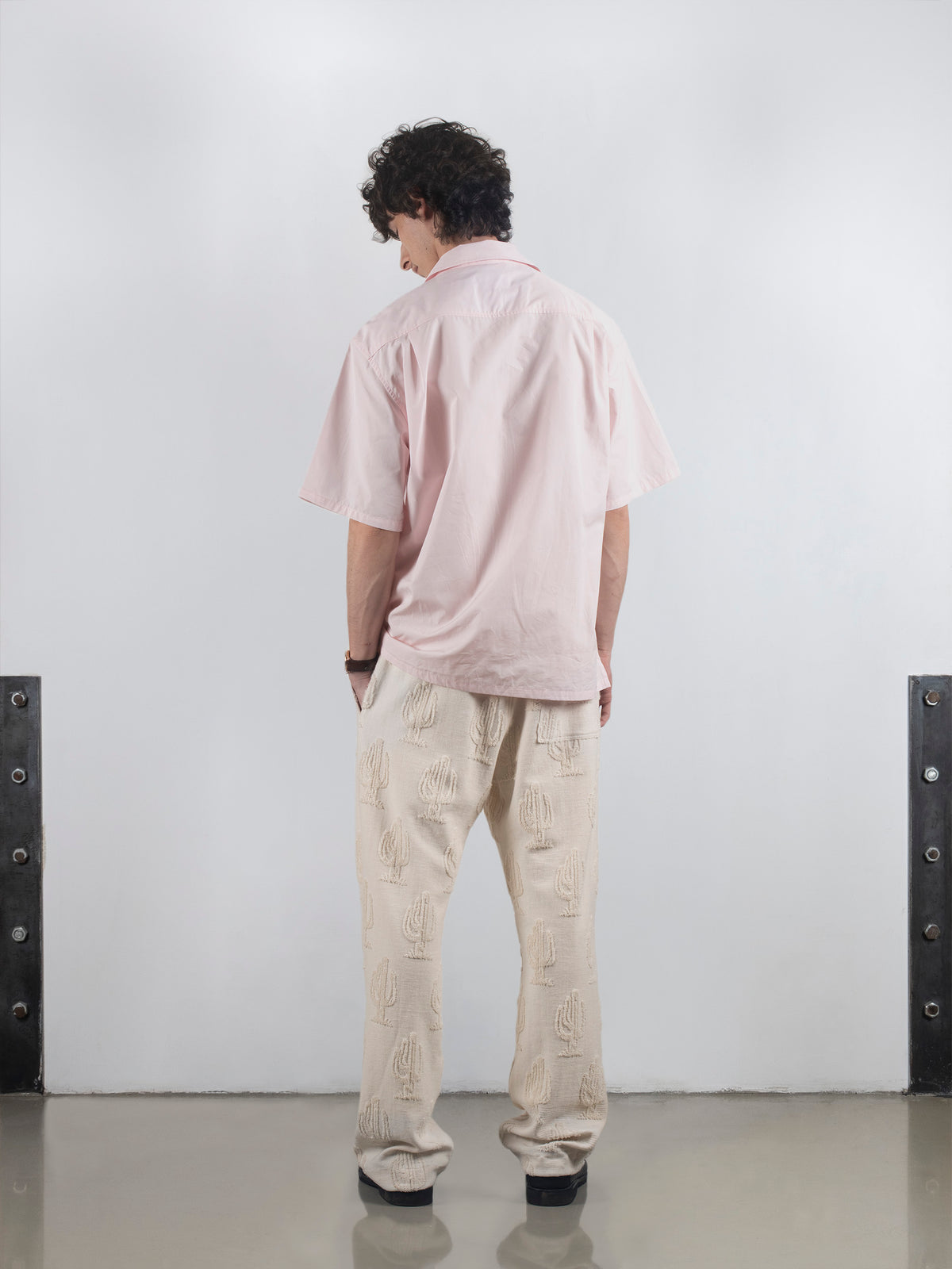 Rear view of man in pink Biasca Bowling Shirt, demonstrating back pleats for comfort, made in France.