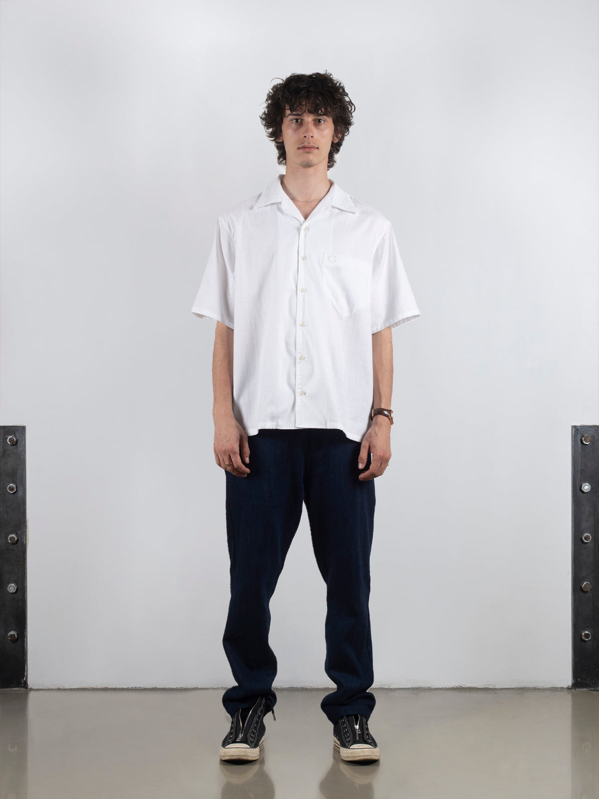 Model wearing crisp white Bowling Shirt with black pants and sneakers.