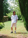 Man wearing a white short sleeved bowling shirt and cool shorts by menswear Crest outdoors.