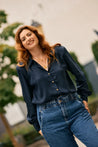 Elegant woman on a date wearing a dark blue Tencel blouse by KS Vestiaire Intemporel