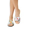 Woman Wearing Floral Print Mules: Image of a woman wearing cross-strap fabric mules with a floral pattern