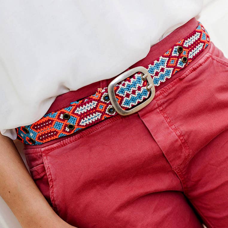 Adriana Handwoven Belt with turquoise and orange geometric pattern worn with red jeans.