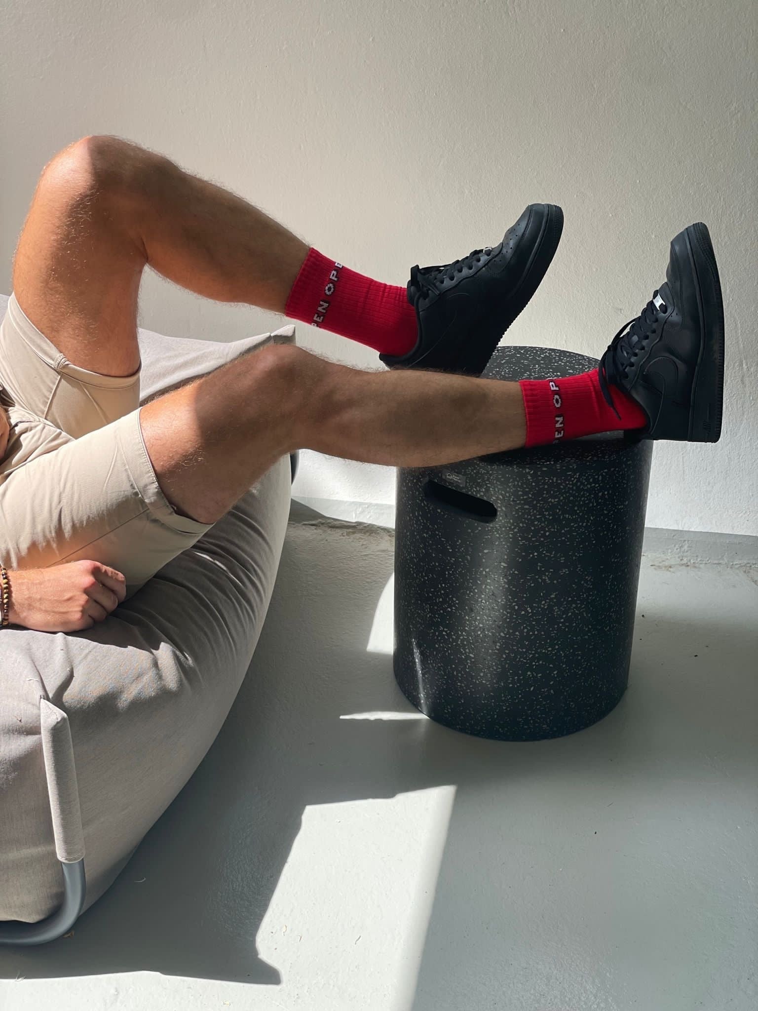 Aman sitting on a bean bag chair wearing colourful red socks by Chaton Gonflable