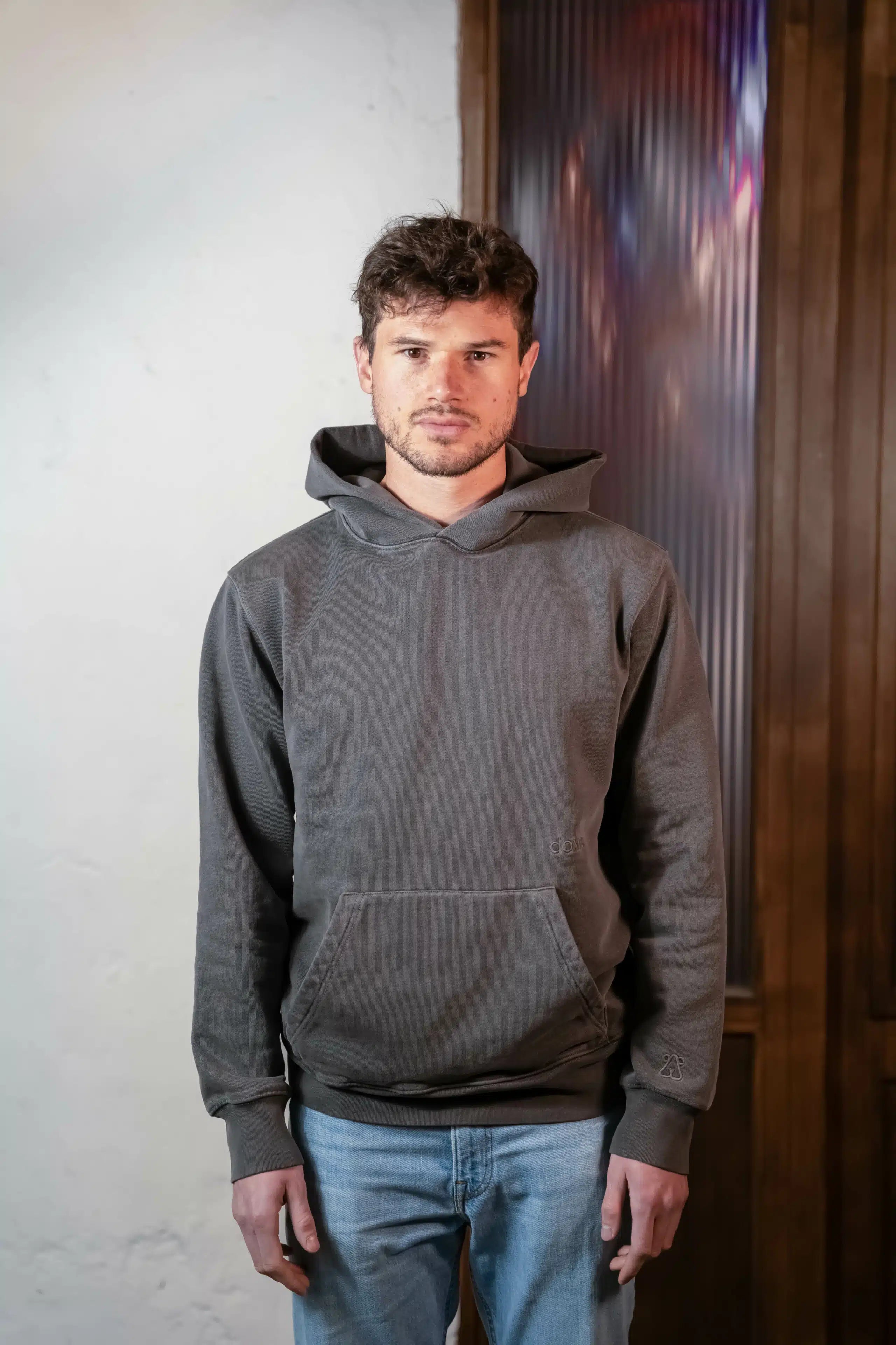 Man wearing Doxa mineral dyed Black Hoodie made from organic cotton jersey.